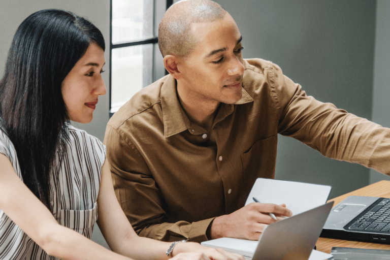 male and female employees working on laptops